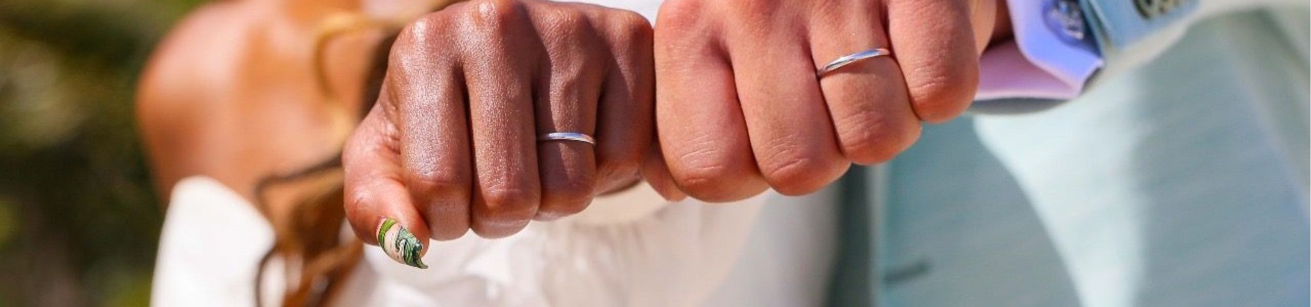 Mains du couple avec alliances lors de leur mariage en Guadeloupe, symbole d'engagement et de bonheur.